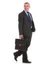 Business man walks with briefcase and looks away Royalty Free Stock Photo