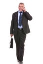 Business man walks with briefcase and on phone Royalty Free Stock Photo