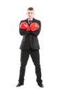 Business man wearing boxing gloves and arms crossed Royalty Free Stock Photo