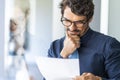 Business man wearing glasses holding paper document folder. Royalty Free Stock Photo