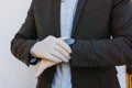 Business man wearing gloves looks the watch. Coronavirus : business man with elastic gloves touches his watch Royalty Free Stock Photo