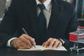 Business man wearing suit and calculates the budget. Shopping cart a on table with note book. Budget of poor low income family. Royalty Free Stock Photo