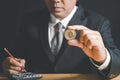 Business man wearing suit and necktie holding bit coin on black background Royalty Free Stock Photo