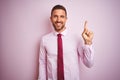 Business man wearing tie and elegant shirt over pink isolated background with a big smile on face, pointing with hand and finger Royalty Free Stock Photo