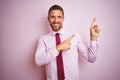 Business man wearing tie and elegant shirt over pink isolated background smiling and looking at the camera pointing with two hands Royalty Free Stock Photo