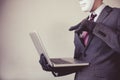 Business man in white mask wearing gloves and using computer - fraud, hacker, theft, cyber crime Royalty Free Stock Photo