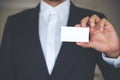 A business man in white shirt and gray suit showing empty business card Royalty Free Stock Photo