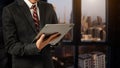 Business man in white shirt using or browsing internet on digital tablet computer with blurred modern office background Royalty Free Stock Photo