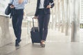 Business man and woman Dragging suitcase luggage bag,walking to passenger boarding in Airport,travel to work.Asian tourist men