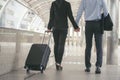 Business man and woman Dragging suitcase luggage bag,walking to passenger boarding in Airport,travel to work.Asian tourist men and Royalty Free Stock Photo