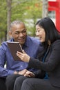 Business man and woman outside on their break with their tablets