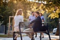 Business man and woman sitting at bench at park and talking Royalty Free Stock Photo
