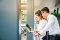 Business man and woman with tablet computer standing talking and