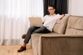 Business man work on sofa and looking at laptop with displeased eyes. Male furrowed brows, staring intently at screen. Royalty Free Stock Photo