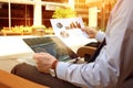 Business man working and analyzing financial figures on a graphs on a laptop outside Royalty Free Stock Photo