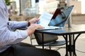 Business man working and analyzing financial figures on a graphs on a laptop outside Royalty Free Stock Photo