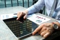 Business man working and analyzing financial figures on a graphs on a laptop outside Royalty Free Stock Photo