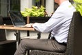 Business man working and analyzing financial figures on a graphs on a laptop outside. Royalty Free Stock Photo