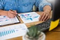 Business man working on a laptop tablet and graph data documents on his desk in home office Royalty Free Stock Photo