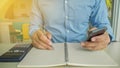 Business man write notebook and hold smart-phone Royalty Free Stock Photo