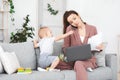 Business And Maternity. Annoyed mom trying to work while toddler distracting her Royalty Free Stock Photo