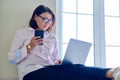 Business mature woman sitting on floor at home using laptop and smartphone Royalty Free Stock Photo