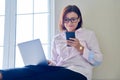 Business mature woman sitting on floor at home using laptop and smartphone Royalty Free Stock Photo