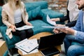 Business meeting cropped image. Young multiethnic people working in office, sitting on sofa around the wooden table with Royalty Free Stock Photo