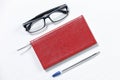 Black glasses, pen and red book isolated on a white table. Royalty Free Stock Photo