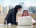 Business Meeting in office , arabian businessman & arabian Secretary wearing hijab working on laptop