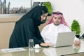 Business Meeting in office , arabian businessman & arabian Secretary wearing hijab working on laptop