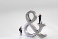 Business men figurines next Ampersand sign