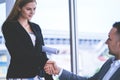 Business man gladly shaking hand with female engineer partner