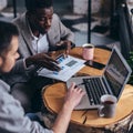 Business men review data at an informal cafe meeting Royalty Free Stock Photo