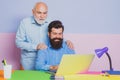 Business men team of two people talk and work together on laptop. Old father and young man looking at laptop screen Royalty Free Stock Photo