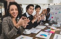 Business men and women of different nationalities were clapping their hands happily and smiling. In the meeting room at the office Royalty Free Stock Photo