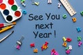 Business message See You Next Year written on blue background, with school supplies Royalty Free Stock Photo