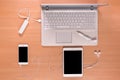 New technology on the desk: open laptop with charging power bank, mobile phone, tablet, headphones and pen with memory stick Royalty Free Stock Photo