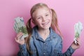 Business and money concept - happy little girl with euro cash money over pink background Royalty Free Stock Photo