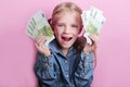 Business and money concept - happy little girl with euro cash money over pink background