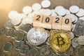2020, Business, Money and cryptocurrency concept. Close up of silver and gold bitcoin on pile of silver coins and wooden number