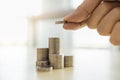 Business, Money, Finance, Secure and Saving Concept. Close up of man hand holding and put three coins to stack of gold coins on Royalty Free Stock Photo