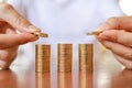 Business, Money, Finance, Secure and Saving Concept. Close up of two man hand holding and put coins to top of stack of gold coins Royalty Free Stock Photo