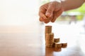 Business, Money, Finance, Secure and Saving Concept. Close up of woman hand holding and put two coins to stack of coins on wooden Royalty Free Stock Photo