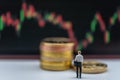 Business Money and Financial Concept. Businessman miniature figure people walking to  stack of gold coins with candlestick chart Royalty Free Stock Photo