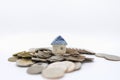 Business, Money, Home Loan and Saving Concept. Closeup of mini house toy on top of pile of coins on white background Royalty Free Stock Photo