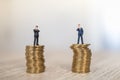 Business, Money Investment and Planning Concept.  Close up of two businessman miniature people figure standing on top of stack of Royalty Free Stock Photo