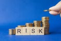 Business, Money and Risk Management Concept. Closeup of man hand holding two gold coin and put to top of stack of coins with