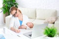 Business mother works at home via Internet with newborn baby Royalty Free Stock Photo