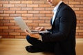 Business man using laptop at home while sitting on floor Royalty Free Stock Photo